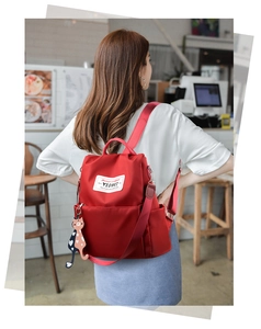 Détail du sac à dos Oxford rouge imperméable avec logo YIOBEI et pendentif chat