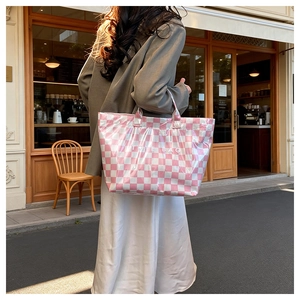 Close-up of pink checkered tote bag with shiny finish and TOTE BAG text print