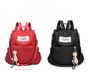 Détail des sacs à dos en tissu Oxford rouge et noir avec pendentifs chat et cœur