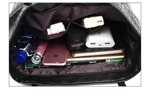 Internal view of a black woven tote bag showing multiple compartments and zippered pocket