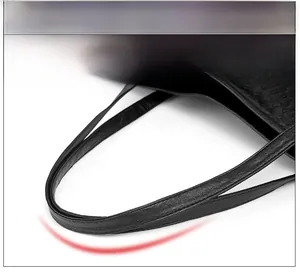 Detail of the ergonomic black woven tote bag handle with refined faux leather texture