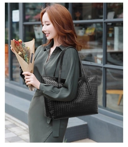 Close-up of black woven leather tote bag featuring detailed grid texture and shoulder straps