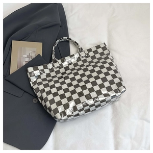 Detailed close-up of a checkered pattern tote bag made of glossy PVC material