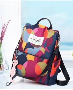 Dettaglio zaino con stampa geometrica colorata e ciondolo a gatto rosa con cuore
