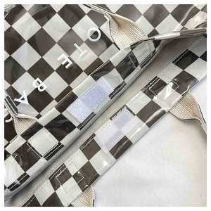 Detail of checkered tote bag showing Velcro closure and reinforced canvas handles