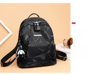 Détail du sac à dos noir imperméable avec motifs géométriques et porte-clé ours