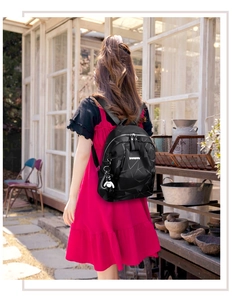 Vue style de vie extérieur d'un sac à dos noir imperméable avec motif géométrique et pendentif ours