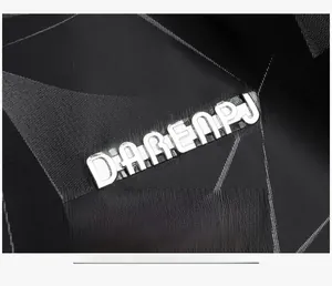 Gros plan du logo métallique DAREAPJ sur un tissu imperméable aux motifs géométriques