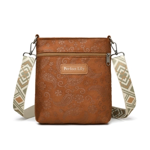 Brown embossed paisley leather crossbody bag with ethnic woven strap on white background