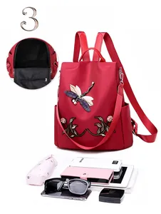 Detail view of red oxford backpack with dragonfly embroidery and its large inner capacity