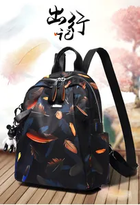 Detail showing the colorful feather print fabric and metal zipper of the backpack