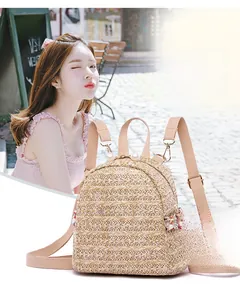 Dettaglio mini zaino in paglia intrecciata con perla su zip e decori floreali
