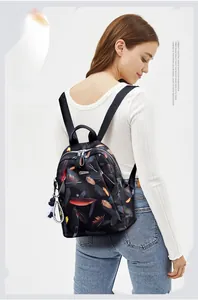 Close-up of lightweight floral backpack featuring feather prints and striped charm