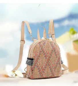 Detail of colorful woven straw backpack featuring pearl zipper and tassel accents