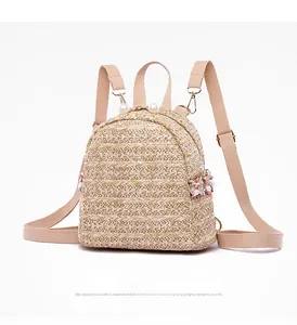 Dettaglio di mini zaino in paglia beige con manico di perle e ricami floreali colorati