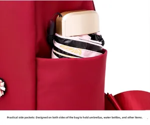Detailed close-up of functional side pocket on red oxford backpack holding a folded umbrella