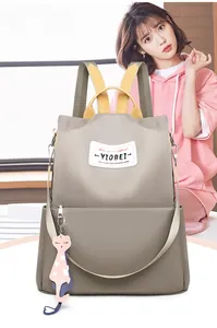 Détail du sac à dos en nylon kaki avec sangles colorées et porte-clés chat mignon