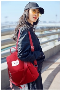 Vue détaillée d'un sac à dos en nylon rouge avec bretelles réglables et charm chat