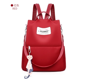 Détail du sac à dos rouge en tissu Oxford avec écusson YIOBEI et pendentif chat
