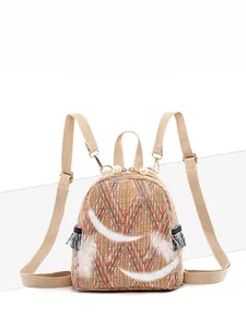 Detail of colorful woven straw mini backpack with geometric pattern and pearl zipper