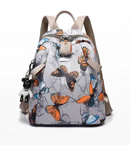 Detailed front view of a lightweight printed backpack featuring butterfly patterns and charms