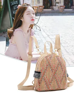 Detail of hand-woven straw backpack with colorful geometric patterns and pearl zipper