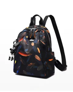 Detail of waterproof backpack with colorful feather prints and a cute black bear charm