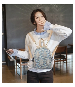 Detail of woven straw mini backpack showing geometric patterns and pearl zipper pulls