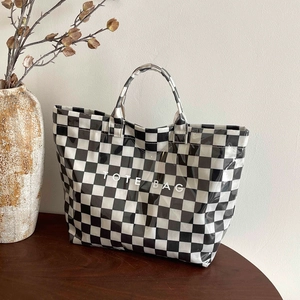 Glossy checkered tote bag with TOTE BAG print on wooden surface with vintage decor