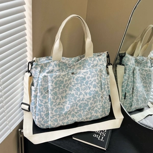 Floral canvas tote bag with adjustable shoulder straps and large front pocket for daily use