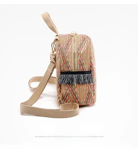 Detail of colorful woven mini backpack with pearl zippers and black side tassels