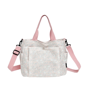 Floral print tote bag with pink straps and adjustable shoulder strap on white background