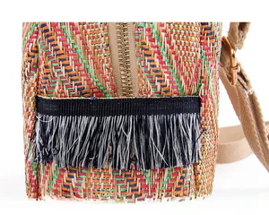 Detail of woven straw backpack showing colorful texture and practical side pocket
