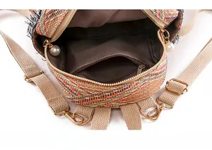 Detail view of woven backpack interior with brown fabric lining and a pearl zipper puller