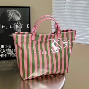 Sac fourre-tout à rayures roses et vertes avec finition brillante sur table en métal