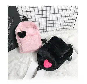 Detailed view of plush fuzzy backpacks in pink and black colors with heart charms
