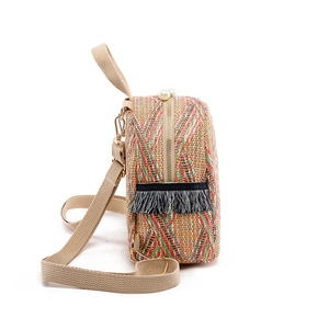 Mini colorful woven backpack with side tassels and pearl zipper on a white background