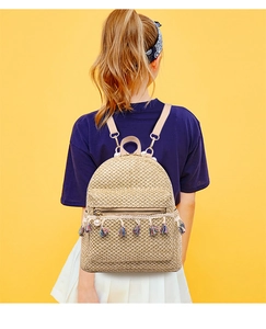 Detail of summer straw backpack featuring colorful tassels and pearl pendant decor