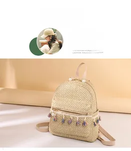 Detailed macro view of woven straw backpack with pearl accents and colorful tassel charms