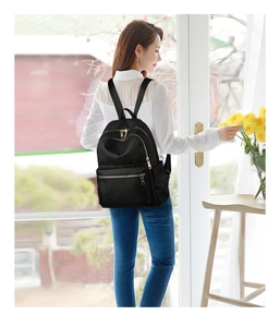 Détail d'un sac à dos en nylon noir imperméable avec des fermetures éclair dorées chic