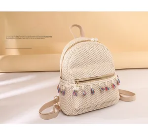 Detail of straw woven backpack with colorful tassel and pearl bead zipper pocket