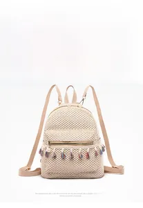 Detail of cream woven backpack with colorful tassels and pearl zipper puller