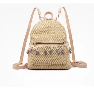 Front view of straw woven backpack featuring colorful tassel trim and pearl zipper pull