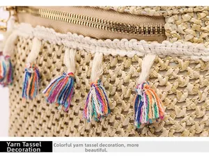 Detail of bohemian straw backpack with golden metal zipper and colorful yarn tassels