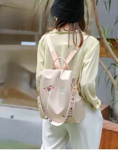 Outdoor-Lifestyle-Foto eines beigen wasserabweisenden Rucksacks mit Blumenstickerei