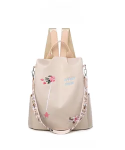Detailansicht der rosa 3D-Stickerei auf einem beigen wasserdichten Rucksack