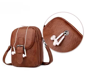 Detail of cross-body phone bag featuring vintage buckle and integrated earphone jack hole
