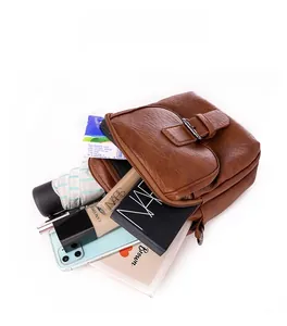 Detailed interior view of multi-compartment brown leather crossbody bag showing storage capacity