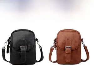 Detail view of small crossbody bags in black and brown with vintage faux leather texture
