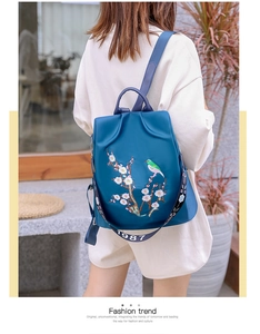 Dettaglio dello zaino in nylon blu navy con ricami tradizionali di uccelli e fiori di prugno